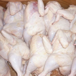 Multiple frozen whole chickens arranged in a container with visible legs and wings.