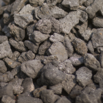 Granular manganese ore consisting of small, dark gray to black stones with a rough texture.