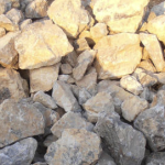 A close-up view of a pile of phosphate rock with various sizes of stones and a light color palette.