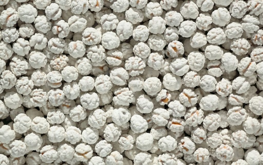 Top view of white sugar-coated fennel seeds creating a textured background.