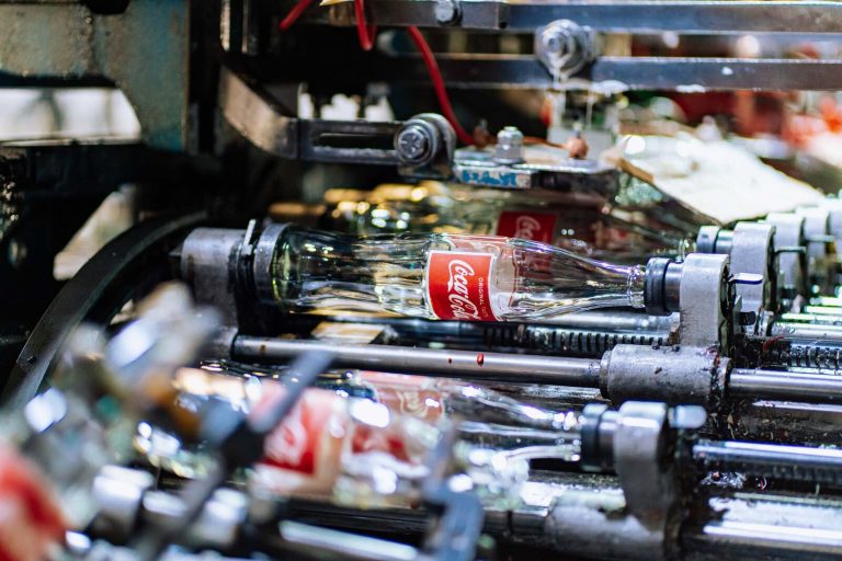 High-quality glass bottles being processed on a factory production line.
