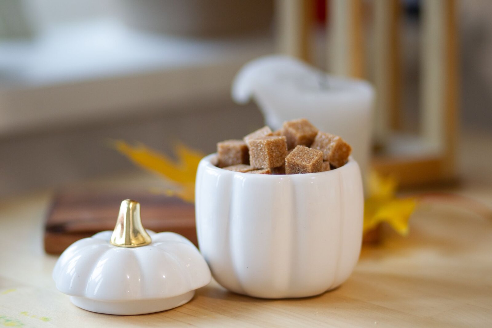 Aesthetic white pumpkin container filled with brown sugar cubes, perfect for autumn decor and cozy settings.